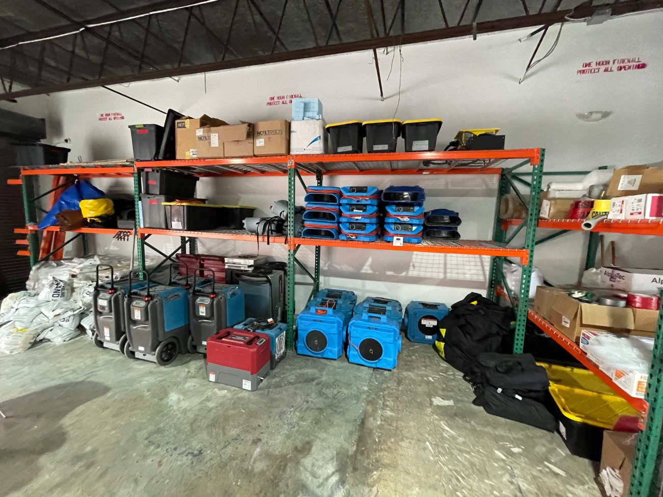 Ready Pro Restoration warehouse: truck-mount extractors, air movers, dehumidifiers and air scrubbers on racking