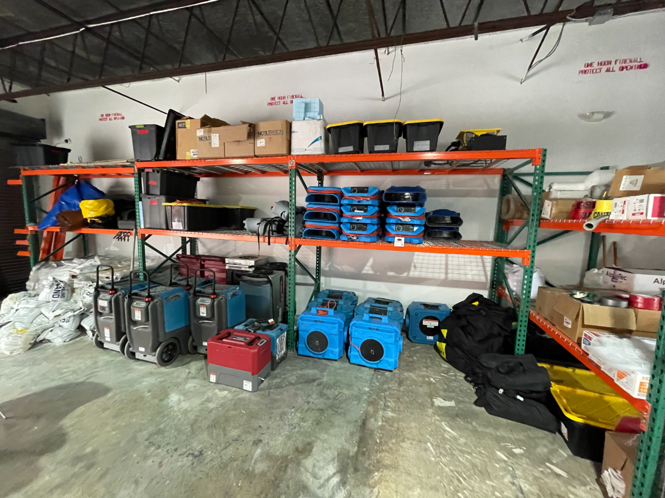 Ready Pro Restoration warehouse: truck-mount extractors, air movers, dehumidifiers and air scrubbers on racking
